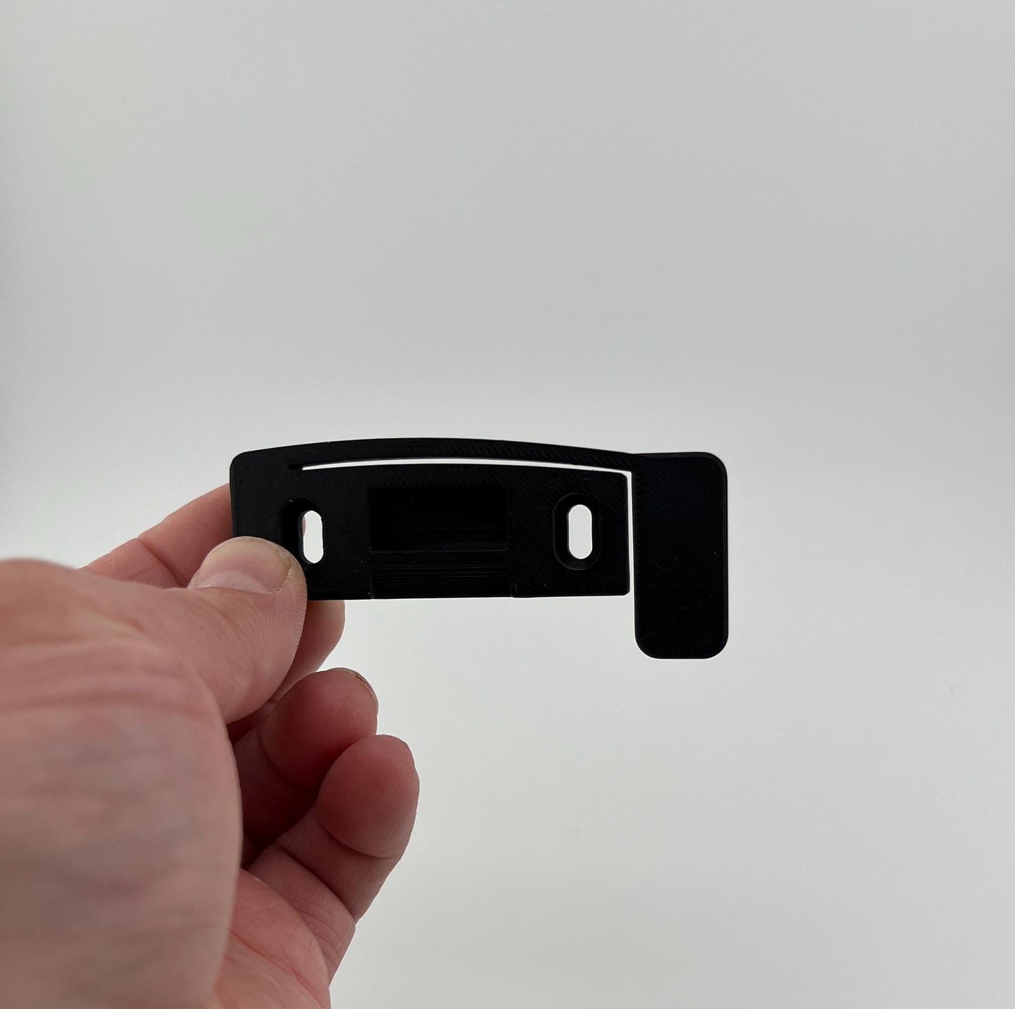 Improved strike plate with pressure foot to reduce door rattle